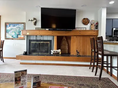 a living room with a fireplace and a flat screen tv at Studio in Lakeside Village, Updated Kitchen & Bath apts in Keystone