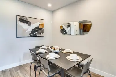 a dining room with a black table and chairs at Brand-New Townhome with Hot Tub, 4 Mi to Winter Park in Fraser