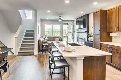 a kitchen and living room with a table and chairs at Brand-New Townhome with Hot Tub, 4 Mi to Winter Park in Fraser
