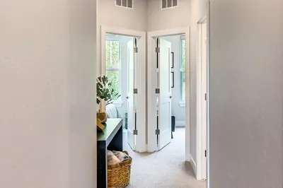 a hallway with white walls and a doorway to a room at Brand-New Townhome with Hot Tub, 4 Mi to Winter Park in Fraser
