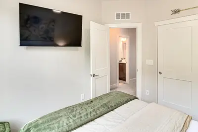 a bedroom with a bed and a television on the wall at Brand-New Townhome with Hot Tub, 4 Mi to Winter Park in Fraser