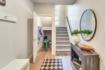 a hallway with a staircase with a mirror and a mirror at Brand-New Townhome with Hot Tub, 4 Mi to Winter Park in Fraser