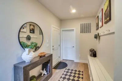 a hallway with a mirror and a vase on a table at Brand-New Townhome with Hot Tub, 4 Mi to Winter Park in Fraser