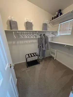 a walk in closet with two hangers and a bench at Unwind in Style in this stunning townhome retreat in Superior