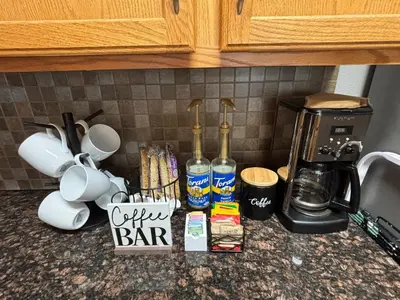 a kitchen counter with bottles of coffee and a coffeemaker at Unwind in Style in this stunning townhome retreat in Superior