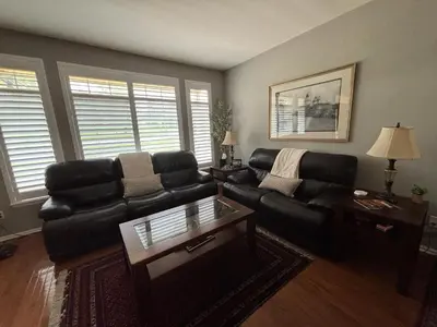 a living room with a black leather couch and a table at Unwind in Style in this stunning townhome retreat in Superior