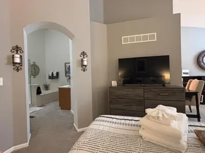 a bedroom with a tv and a bed with a dresser at Unwind in Style in this stunning townhome retreat in Superior