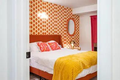 a bedroom with a bed with a yellow blanket at Stylish House with Hot Tub, Fire Pit Pool table near Denver in Arvada