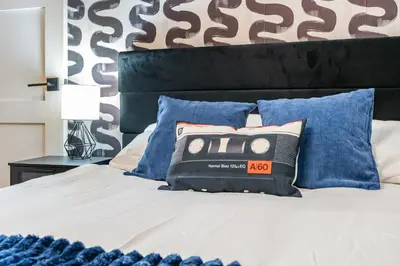 a bedroom with a white bed with blue pillows at Stylish House with Hot Tub, Fire Pit Pool table near Denver in Arvada