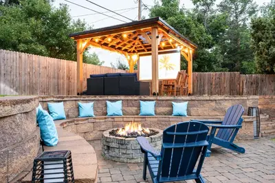 a patio with a fire pit and chairs and a gazebo at Stylish House with Hot Tub, Fire Pit Pool table near Denver in Arvada