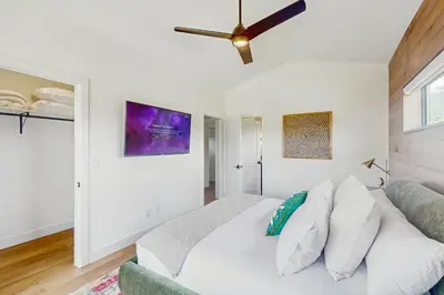 a bedroom with a white bed and a ceiling fan at Moose Mountain Lodge in Fraser