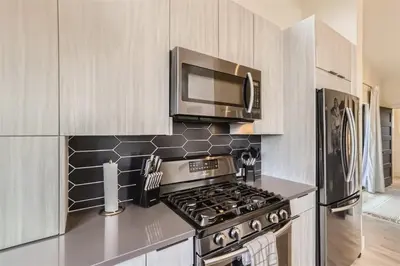 a kitchen with a stove and a microwave at Pinebox at Evergreen Modern 20Acres -Serene-Creek in Evergreen