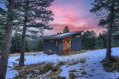 a tiny house in the woods in the snow at Pinebox at Evergreen Modern 20Acres -Serene-Creek in Evergreen