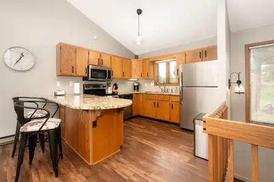 a kitchen with wooden cabinets and a white refrigerator at Bright & Spacious Mtn Retreat in Fraser