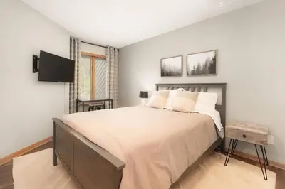a bedroom with a large bed and a tv at Bright & Spacious Mtn Retreat in Fraser