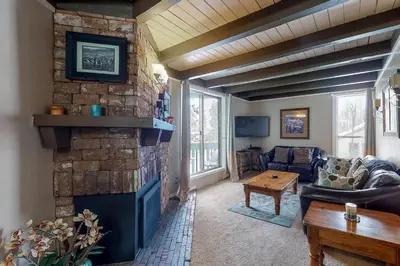 a living room with a stone fireplace and a couch at Lodge Pole Condo in Silverthorne