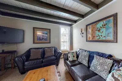 a living room with leather furniture and a flat screen tv at Lodge Pole Condo in Silverthorne