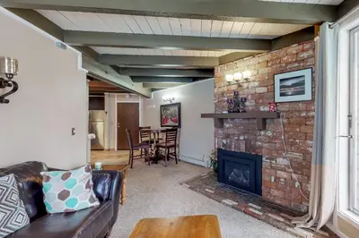 a living room with a fireplace and a brick wall at Lodge Pole Condo in Silverthorne