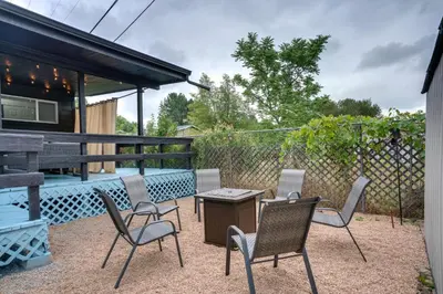 a patio with chairs and a table and a fence at Game Room and Fire Pit Family-Friendly Loveland Gem in Loveland