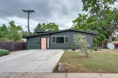 a small green house with a driveway at Game Room and Fire Pit Family-Friendly Loveland Gem in Loveland