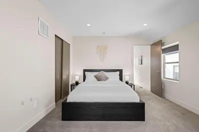 a bedroom with a large bed with white sheets at Modern Townhome for long stays Near Sloans Lake in Denver