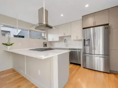 a kitchen with white cabinets and a stainless steel refrigerator at Modern Townhome for long stays Near Sloans Lake in Denver