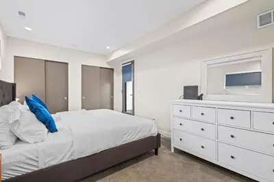 a bedroom with a bed and a dresser with a tv at Modern Townhome for long stays Near Sloans Lake in Denver