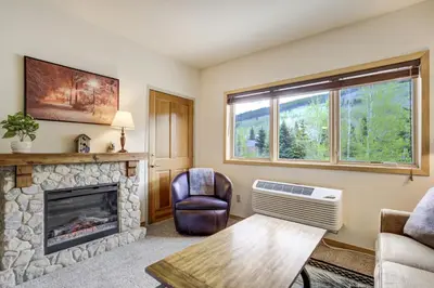 a living room with a fireplace and a couch at Gateway Studio - Pool, Hot Tub, Walk to Slopes in Keystone