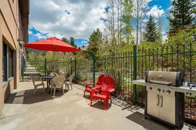 a patio with a table and chairs and a grill at Gateway Studio - Pool, Hot Tub, Walk to Slopes in Keystone