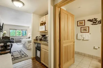 a kitchen with a door leading to a bedroom at Gateway Studio - Pool, Hot Tub, Walk to Slopes in Keystone