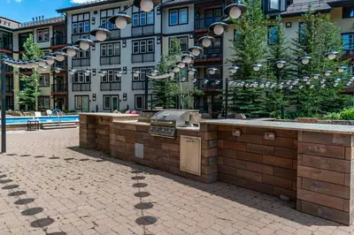a building with an outdoor kitchen in front of it at Founders Pointe 4569 Ski In Ski Out Winter Park Resort in Winter Park