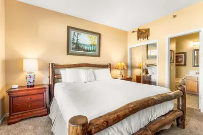 a bedroom with a large bed with a wooden frame at 2 Bedroom Hot Tub Fireplace Walk to Lake Dillon in Frisco
