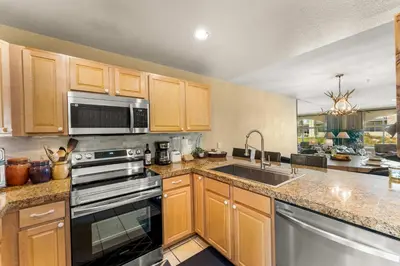 a kitchen with wooden cabinets and stainless steel appliances at 2 Bedroom Hot Tub Fireplace Walk to Lake Dillon in Frisco