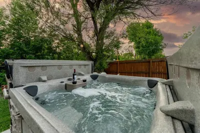 a jacuzzi tub with a bottle of wine in it at 5BD Japanese-Themed w/ Hot Tub, Movie Room & Games in Arvada