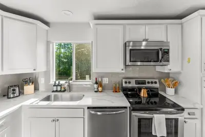 a white kitchen with a sink and a microwave at 5BD Japanese-Themed w/ Hot Tub, Movie Room & Games in Arvada