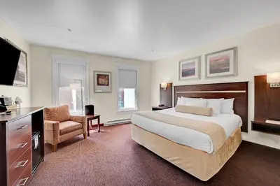 a hotel room with a large bed and a chair at Century Casino & Hotel - Central City in Central City