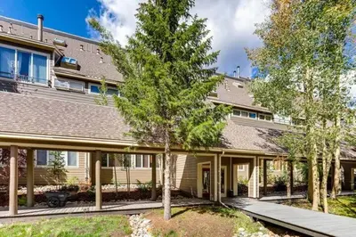 a house with a tree in front of it at 1-Bedroom plus Loft at The Pines with Forest Views, No Cleaning Fees, Kids Ski Free condo in Keystone