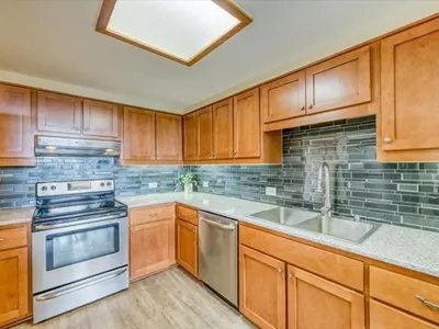a kitchen with wooden cabinets and stainless steel appliances at 1-Bedroom plus Loft at The Pines with Forest Views, No Cleaning Fees, Kids Ski Free condo in Keystone