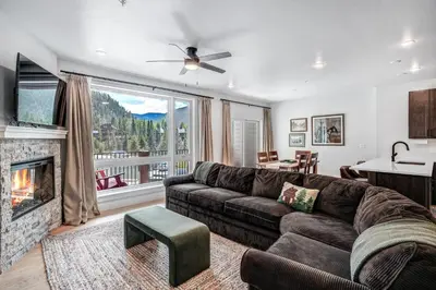 a living room with a couch and a fireplace at Spacious and Luxurious 2BR Condo - Kids Ski Free condo in Keystone