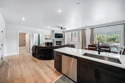 a kitchen with a sink and a living room at Spacious and Luxurious 2BR Condo - Kids Ski Free condo in Keystone