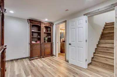a hallway with a staircase and white walls and wood floors at Luxury Spacious House Great for a Family Retreat in Loveland