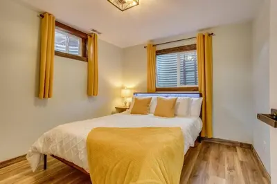 a bedroom with a bed with yellow curtains and a window at Luxury Spacious House Great for a Family Retreat in Loveland