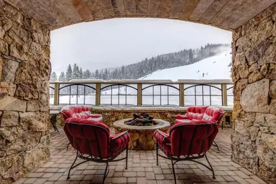 a patio with red chairs and a table with a view at Lone Eagle 3052 in Keystone