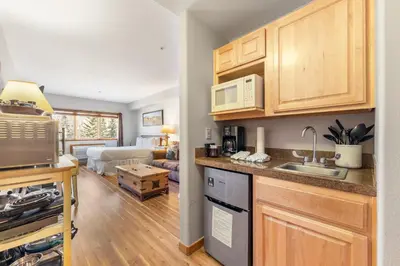 a kitchen with wooden cabinets and a living room at Gateway 5028 in Keystone