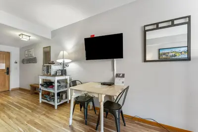 a dining room with a table and a tv on a wall at Gateway 5028 in Keystone