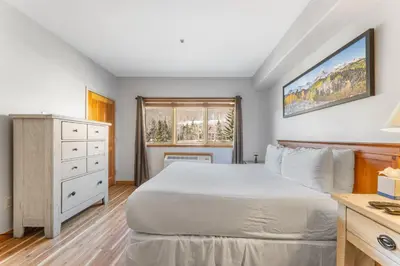 a bedroom with a bed and a dresser and a window at Gateway 5028 in Keystone