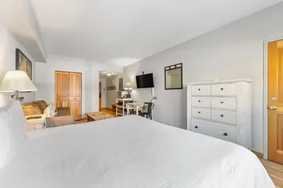 a bedroom with a white bed and a living room at Gateway 5028 in Keystone