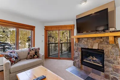 a living room with a fireplace and a tv at Red Hawk Lodge 2267 in Keystone