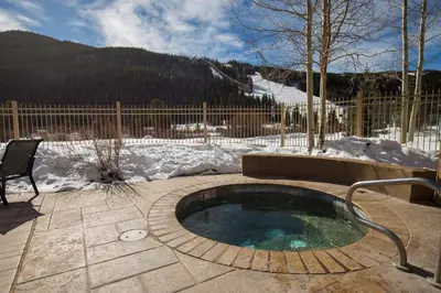a hot tub in a patio with snow on the ground at Red Hawk Lodge 2267 in Keystone