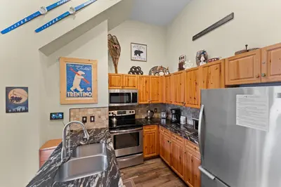 a kitchen with wooden cabinets and a stainless steel refrigerator at Expedition Station 8633 in Keystone